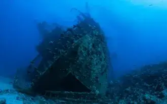 Scuba divers exploring the wreckage of a sunken ship.